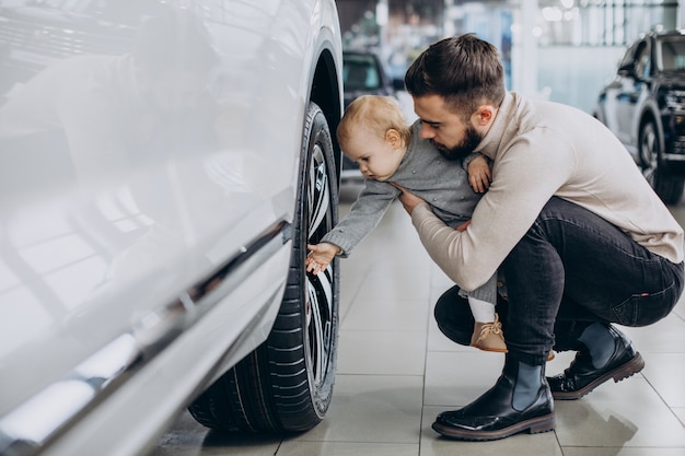 Foto grátis pai com filha bebê em um showroom de carros