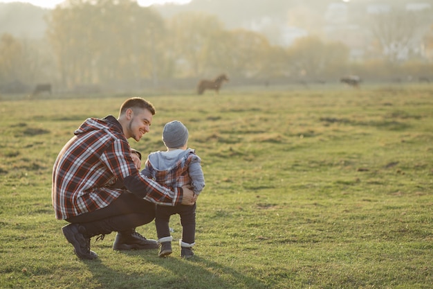 Pai com filho caminhando em um campo de manhã