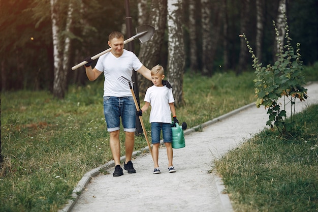 Pai com filho pequeno estão plantando uma árvore em um parque