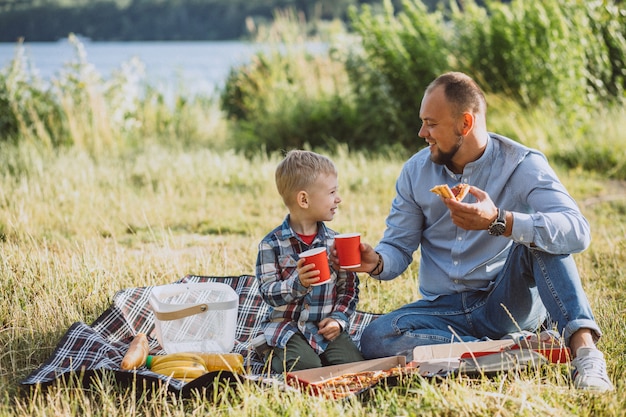 Pai com seu filho fazendo piquenique no parque