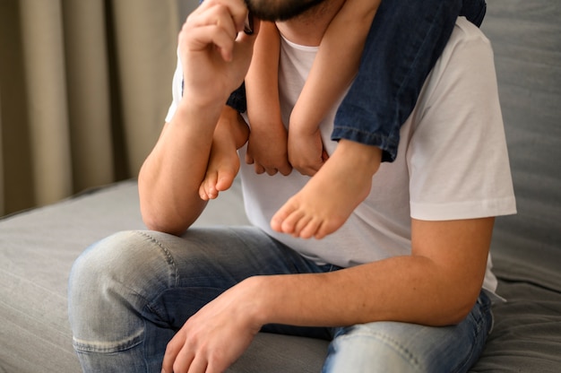 Pai de close-up, segurando o filho nos ombros