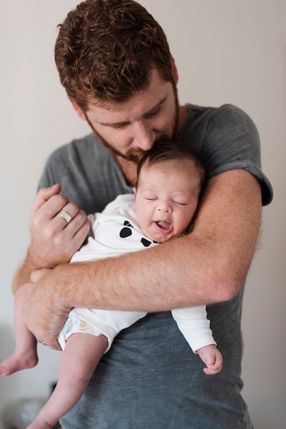 Foto grátis pai de tiro médio com seu bebê