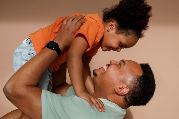 Foto grátis pai de tiro médio e menina posando no estúdio