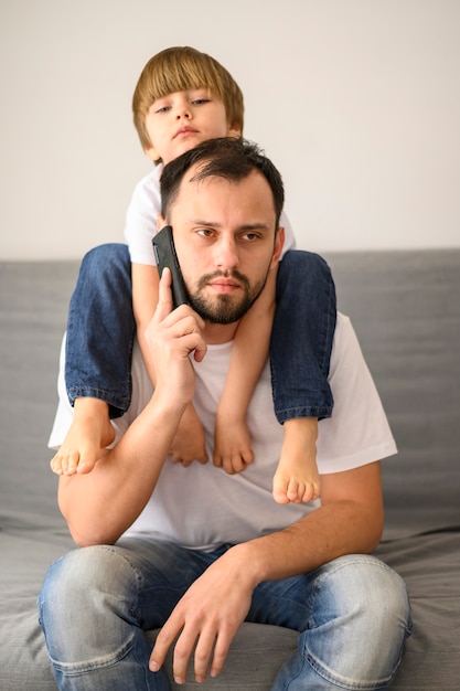 Pai de tiro médio falando ao telefone