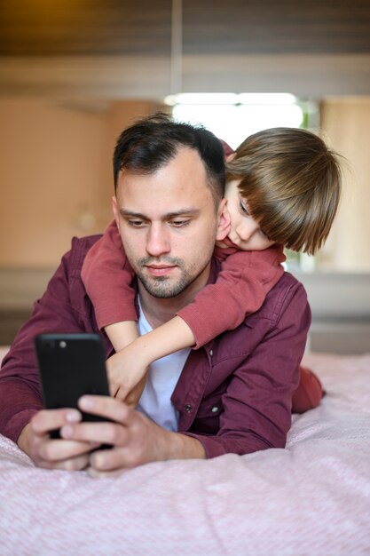 Pai de tiro médio, segurando o telefone