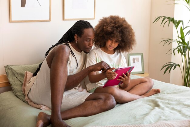 Pai e filha brincando juntos em um tablet