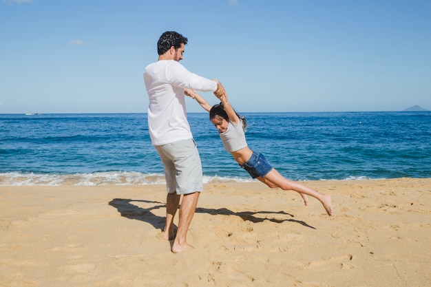 Pai e filha brincando na praia