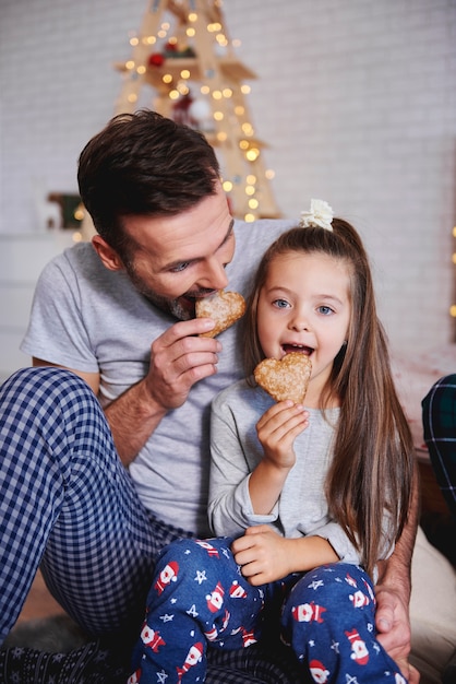 Pai e filha comendo pão de gengibre no natal