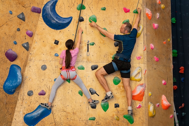 Pai e filha escalando juntos dentro de casa na arena