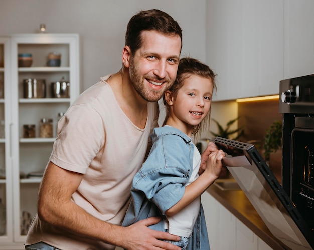 Foto grátis pai e filha fazendo biscoitos juntos em casa