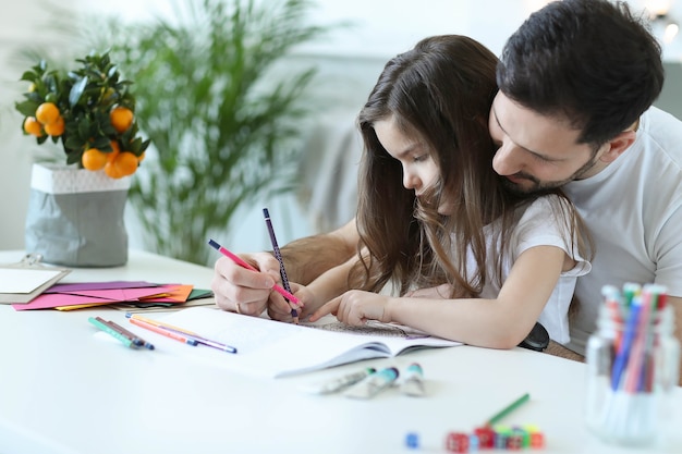 Foto grátis pai e filha fazendo dever de casa