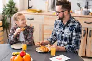 Foto grátis pai e filha juntos na mesa de café da manhã