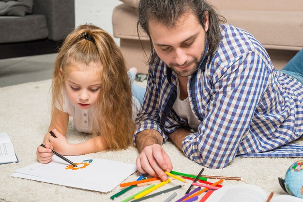 Pai e filha pintando no chão