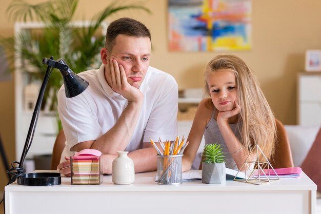 Pai e filha sentada em uma mesa