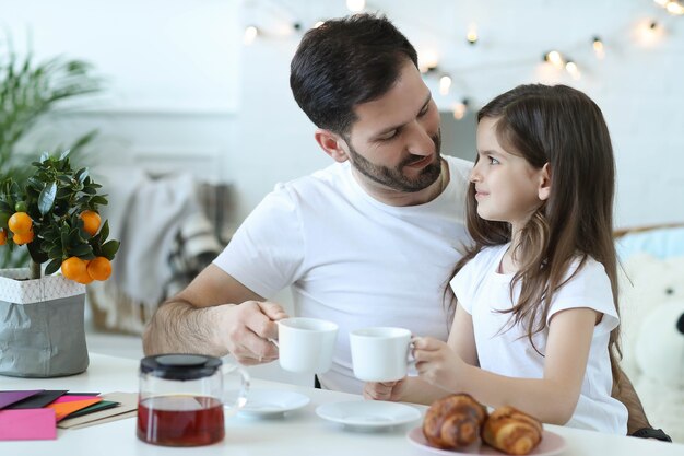 Pai e filha tomando café da manhã na cozinha