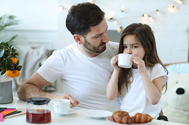 Pai e filha tomando café da manhã na cozinha
