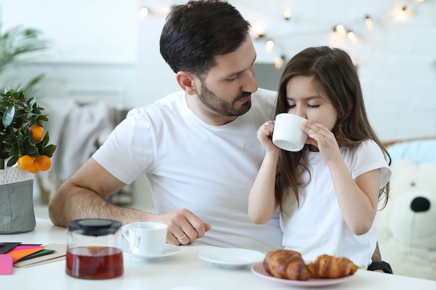 Pai e filha tomando café da manhã na cozinha