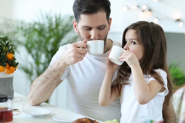 Pai e filha tomando café da manhã na cozinha