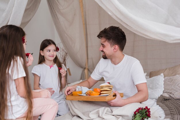 Pai e filhas tomando café da manhã no dia dos pais