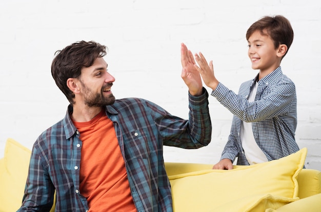 Pai e filho a sorrir batem cinco