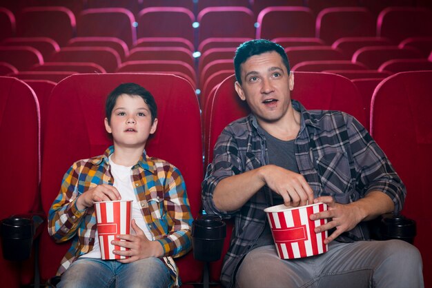 Pai e filho assistindo filme no cinema