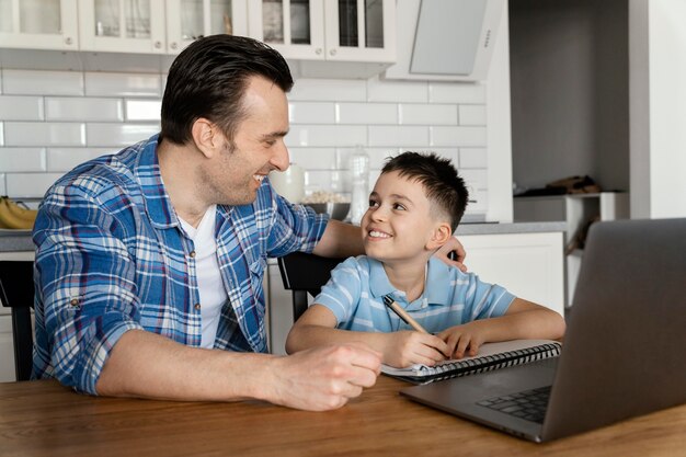 Pai e filho com laptop em tiro médio