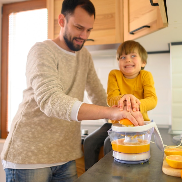 Pai e filho fazendo suco de laranja
