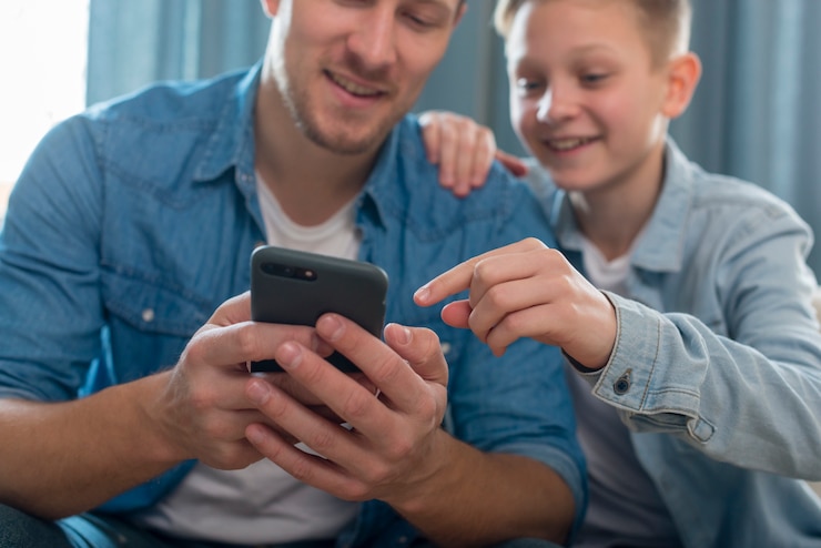 Foto grátis pai e filho fofo brincando no telefone