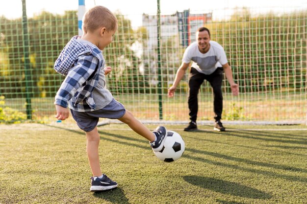 Pai e filho jogando futebol