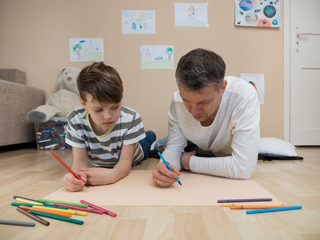 Foto grátis pai e filho juntos a desenhar no chão