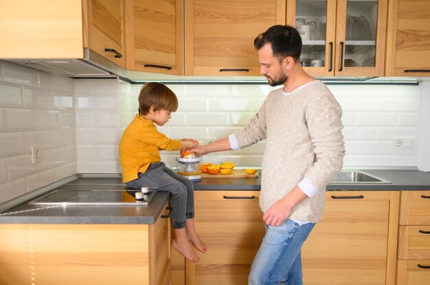 Pai e filho na cozinha fazendo um suco