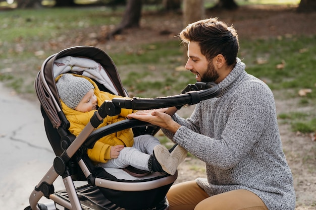 Foto grátis pai e filho no carrinho ao ar livre na natureza