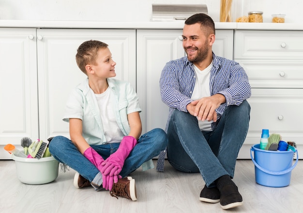 Pai e filho posando durante a limpeza da casa