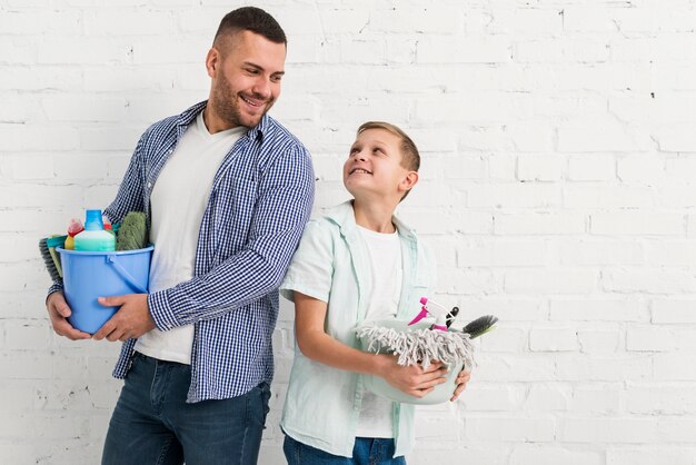 Pai e filho posando junto com produtos de limpeza