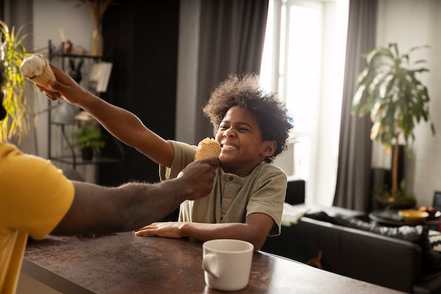 Foto grátis pai e filho tomando sorvete juntos na cozinha