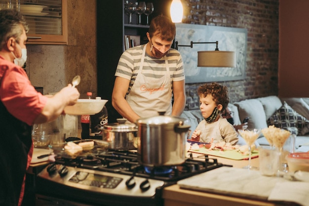 Pai e filhos cozinham macarrão em uma master class em gastronomia