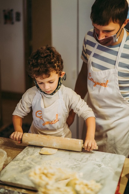 Pai e filhos cozinham macarrão em uma master class em gastronomia
