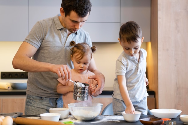 Pai e filhos em tiro médio na cozinha