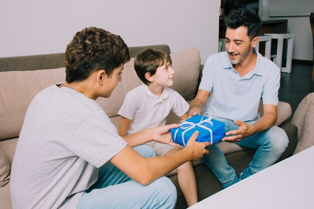 Pai e filhos no sofá no dia dos pais