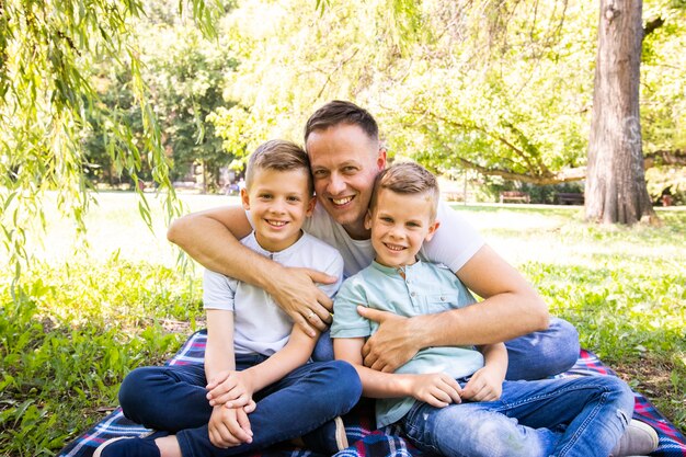 Pai e filhos posando enquanto olha para a câmera