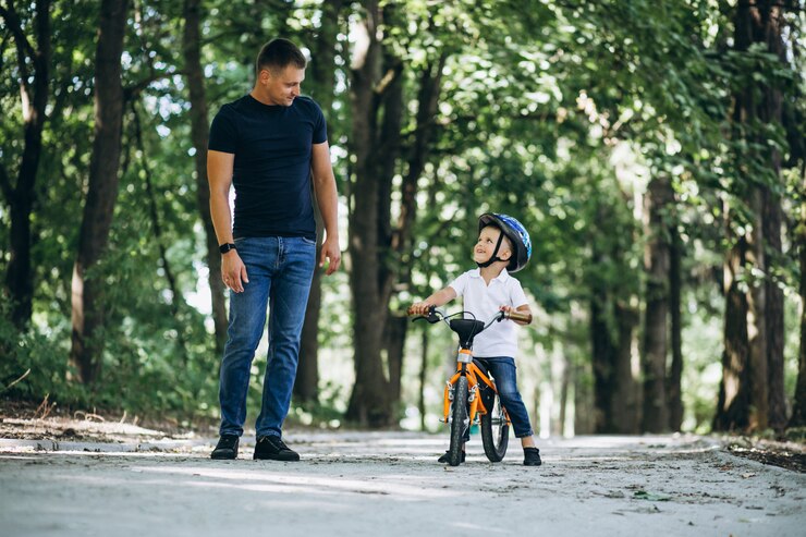 Foto grátis pai ensinando seu filho a andar de bicicleta