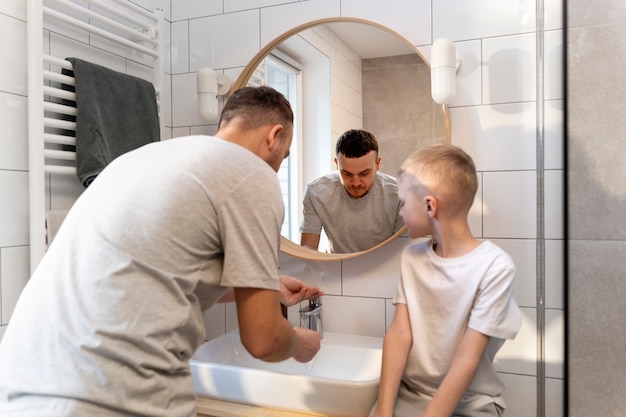 Foto grátis pai ensinando seu filho a fazer a barba