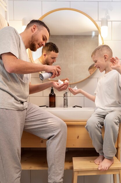 Foto grátis pai ensinando seu filho a fazer a barba