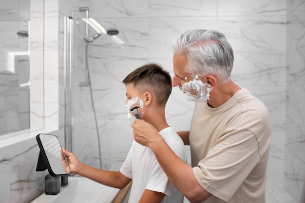 Foto grátis pai ensinando seu filho a fazer a barba