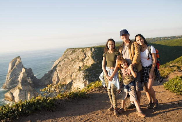 Foto grátis pai feliz caminhando com os filhos nas montanhas