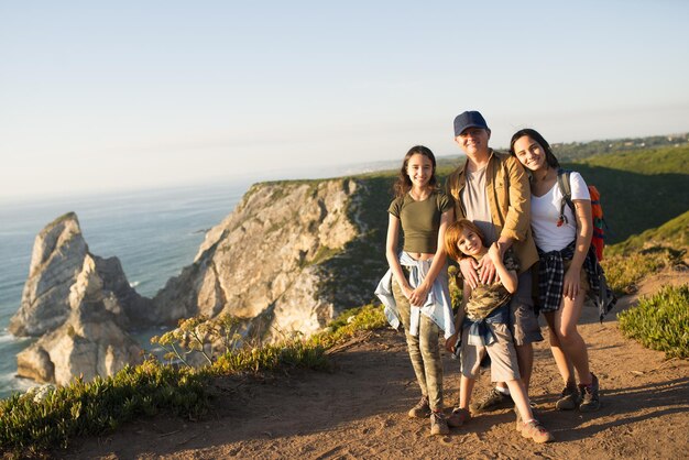 Pai feliz caminhando com os filhos nas montanhas