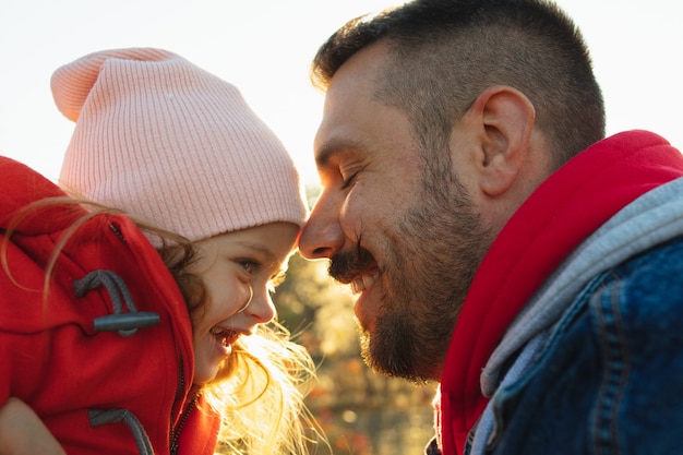 Pai feliz e filha pequena correndo pelo caminho da floresta em um dia ensolarado de outono. tempo para a família, togehterness, parentalidade e conceito de infância feliz. fim de semana junto com emoções sinceras.