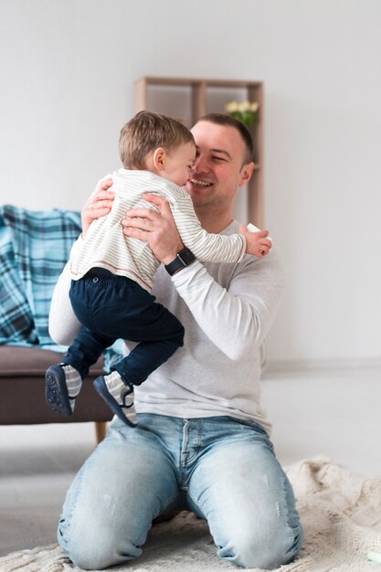 Pai feliz, segurando o filho em casa