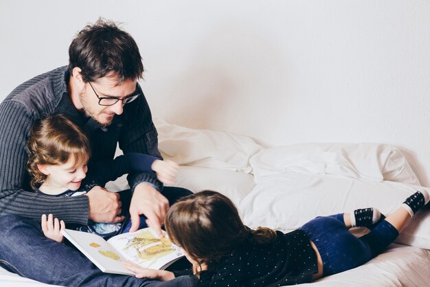 Pai lendo história engraçada para meninas