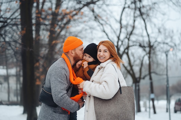 Pai mãe e bebê no parque no inverno